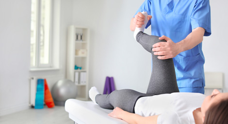 A medical professional working on a womans knee