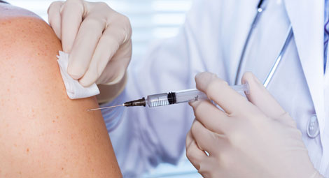 Close up of the arm of a patient where the clinician is vaccinating them